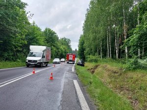 Na prawym pasie jezdni stoi samochód straży pożarna. Obok niego, na poboczu drogi, stoi pojazd marki Citroen. Przed nim, na przydrożnej skarpie widoczne są ślady po uderzeniu samochodu.