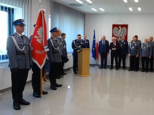 Zastępca Komendanta Wojewódzkiego Policji w Rzeszowie stoi przy mównicy i wygłasza okolicznościowe przemówienie.