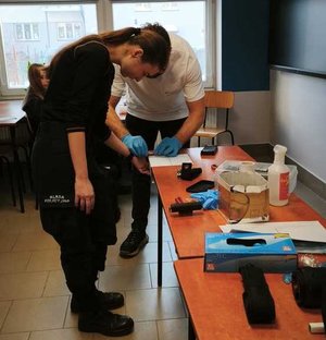 Policyjny technik pobiera odciski palców od jednej z uczelnic.