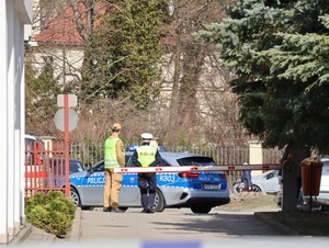 Umundurowani policjanci i oznakowany radiowóz przed Centrum Medycznym w Łańcucie.