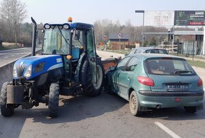 Stojący przy ciągnik rolniczym samochód marki Peugeot.
