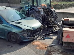 Stojący przy ciągnik rolniczym samochód marki Peugeot.
