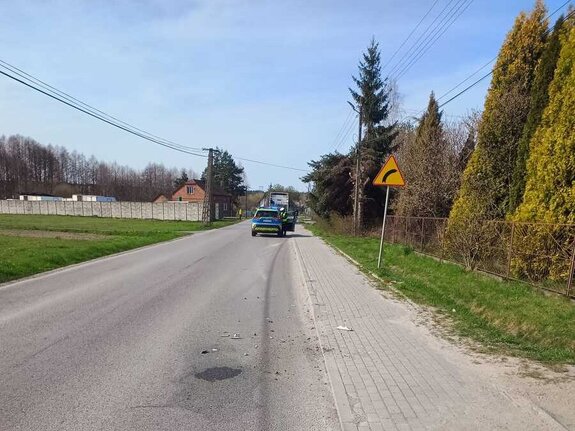 Oznakowany radiowóz stojący w pobliżu miejsca zdarzenia.