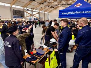 Uczniowie przy policyjnym stoisku przymierzają alkogogle.