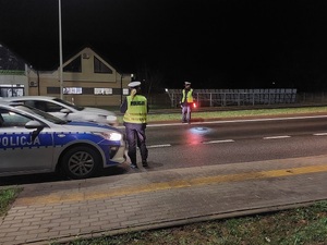 Policjanci ruchu drogowego przeprowadzają kontrolę drogową.