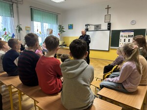 Dzielnicowy wygłasza pogadankę dla uczniów