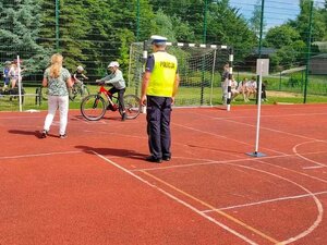 Policjant ocenia prawidłową jazdę rowerem ucznia.