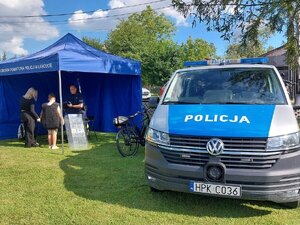 Stoisko policyjne. Policjant pokazuje policyjne wyposażenie i umundurowanie.