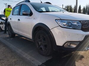 Uszkodzony pojazd marki Dacia, za nim widoczny uszkodzony pojazd marki Citroen.